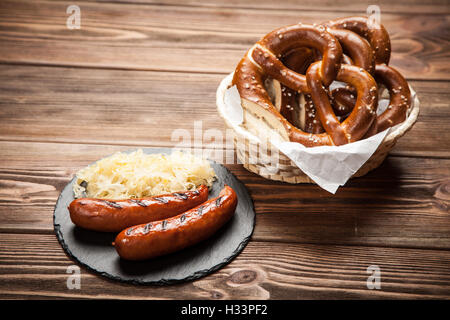 Bretzels, saucisses et choucroute sur table en bois Banque D'Images