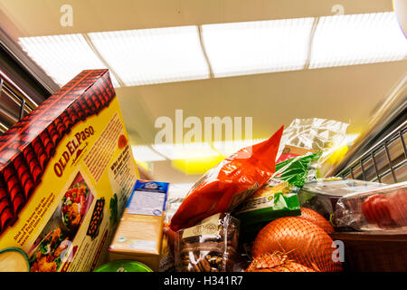 Supermarket shopping in trolley groceries in shopping cart pushing around store shop supermarkets grocery food inside interior Banque D'Images