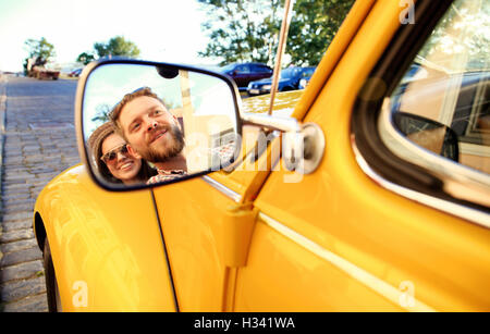 Couple. Belle jeune couple enjoying road trip in convertible et regarder avec le sourire Banque D'Images