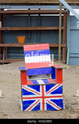 Chaise en bois dans le sable peint avec un Union Jack Banque D'Images