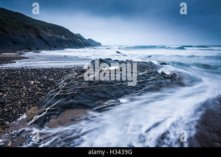 La marée entrante et les rochers sur la plage de Crackington Haven avec la pointe de Cambeak au-delà sur la côte nord de Cornwall. Angleterre. Banque D'Images