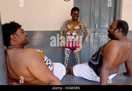 Danseurs formés obtenir leur corps peint aux couleurs tiger ils se préparent à participer à la célèbre Pulikali Kerala Thrissur Banque D'Images