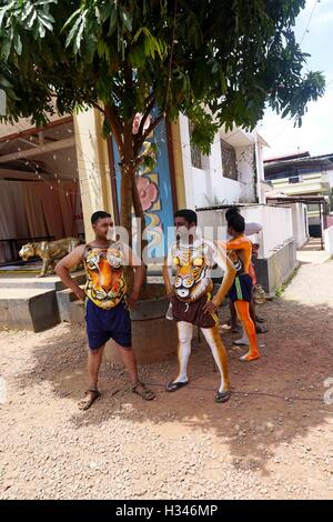 Danseurs formés obtenir leur corps peint aux couleurs d'un tigre se préparent à participer célèbre Pulikali Kerala Thrissur Banque D'Images