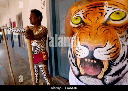 Danseurs formés obtenir leur corps peint aux couleurs tiger se préparent à participer à la célèbre Pulikali Kerala Thrissur Banque D'Images