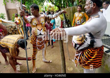 Danseurs formés obtenir leur corps peint aux couleurs d'une tige se préparent à participer célèbre Pulikali Kerala Thrissur Banque D'Images