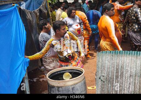 Danseurs formés obtenir leur corps peint aux couleurs d'un tigre se préparent à participer à la célèbre Pulikali Kerala Thrissur Banque D'Images