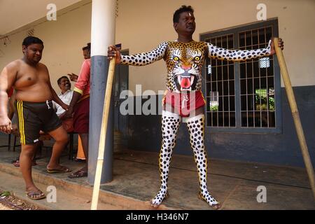 Danseurs formés obtenir leur corps peint aux couleurs d'un tigre préparer participer à la célèbre Pulikali Kerala Thrissur Banque D'Images