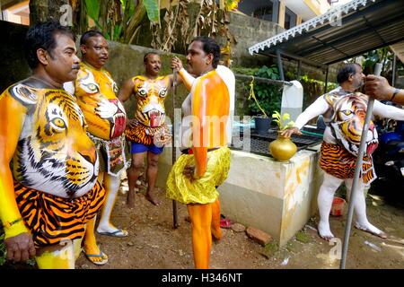 Danseurs formés obtenir leur corps peint aux couleurs d'un tigre se préparent à participer célèbre Pulikali Kerala Thrissur Banque D'Images