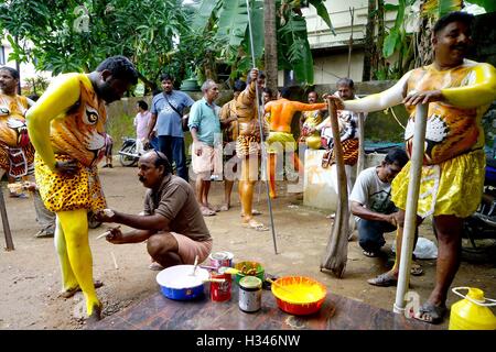 Danseurs formés obtenir leur corps peint aux couleurs d'un tigre se préparent à participer célèbre Pulikali Kerala Thrissur Banque D'Images