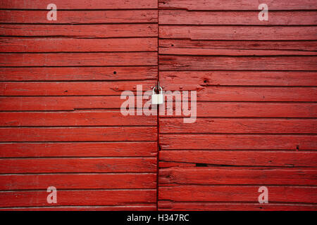 Vieille porte en bois rouge avec le cadenas fermé Banque D'Images