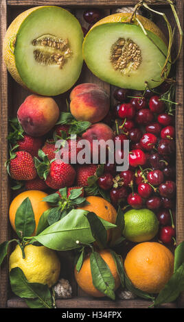Variété de fruits d'été en bonne santé. Le Melon, cerise douce, pêche, fraise, orange et citron sur plateau en bois historique Banque D'Images