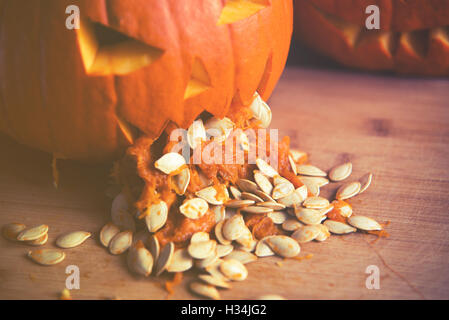 Close up sur Pumpkin vomir avec les graines de citrouille sur la table en bois Banque D'Images