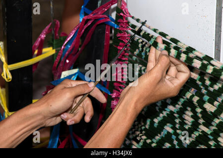 L'INDONÉSIE, Bali, Singaraja, Pertenunan Berdikari atelier de tissage, des mains de travailleur part mourir l'ikat de trame Banque D'Images