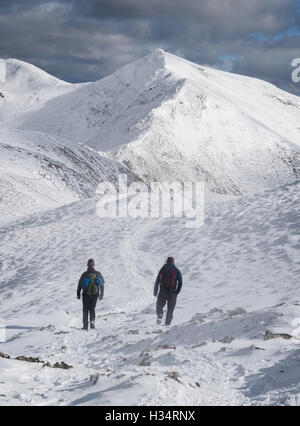 Les promeneurs sur la crête en direction de Hopegill Whiteside Head en hiver dans le parc national de Lake District, England, UK Banque D'Images