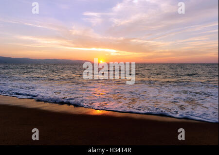 Ocean sunset est une pièce lumineuse avec un paysage marin d'or gentle wave rouler à la rive. Banque D'Images