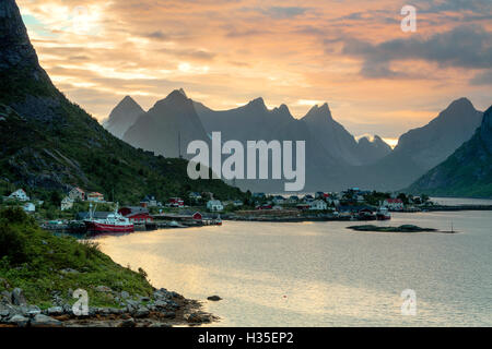 Coucher du soleil sur le village de pêcheurs entouré de pics rocheux et de la mer, Reine, comté de Nordland, îles Lofoten, Norvège, de l'Arctique Banque D'Images