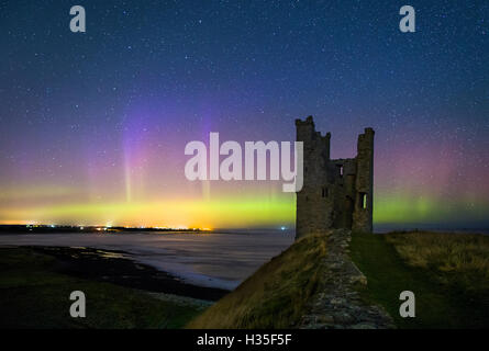 Les aurores boréales au château de Dunstanburgh, Northumberland Banque D'Images