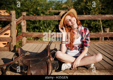 Portrait of smiling young woman in hat cowgirl et chemise à carreaux Banque D'Images