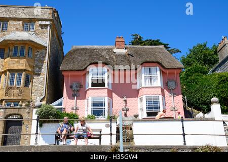 Vue de la bibliothèque de chaume peint rose cottage le long de Marina Parade, Lyme Regis, dans le Dorset, Angleterre, Royaume-Uni, Europe de l'Ouest. Banque D'Images