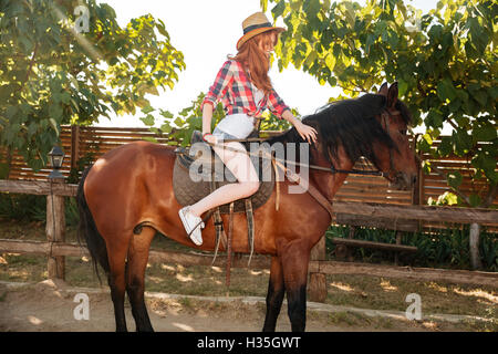 Jeune femme rousse Happy smiling cowgirl et riding horse Banque D'Images