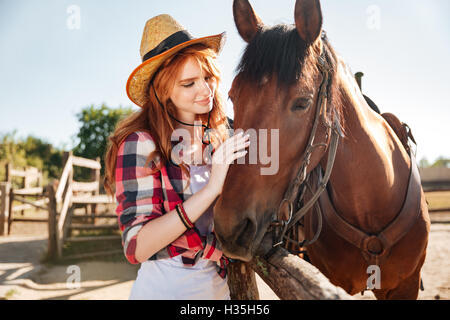 Portrait de jeune femme hand cowgirl avec son cheval sur le ranch Banque D'Images