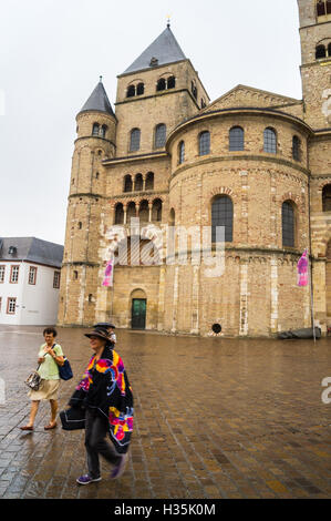 Les touristes dans la pluie à l'extérieur, Dom Trierer grande cathédrale romane de Saint Pierre, Domplatz, Trèves, Rhénanie-Palatinat, Allemagne Banque D'Images