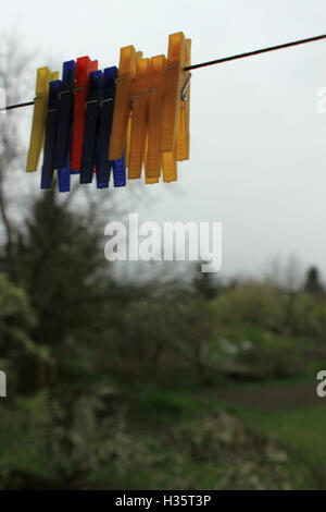 Pinces à linge en plastique coloré pendu à une corde à linge Banque D'Images