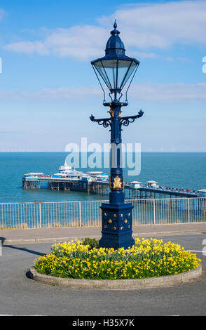 Lampost et des jonquilles à Happy Valley, avec vue sur la jetée de Llandudno, Conwy, Pays de Galles, Royaume-Uni Banque D'Images