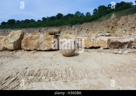 Une grande carrière de fonte ouverte avec de vieux bâtiments en étain, des équipements de fabrication et de la pierre blanche, placé contre un ciel bleu profond. Banque D'Images