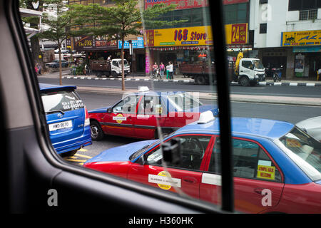 Scène de rue avec les taxis et voitures dans la capitale malaisienne Kuala Lumpur. Banque D'Images
