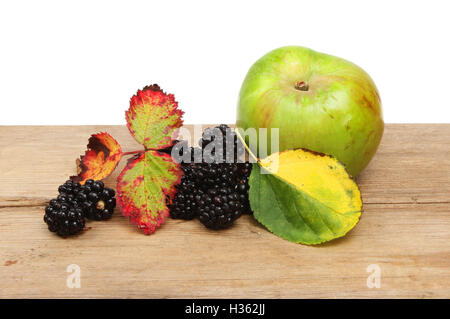 Fruits d'automne, mûres et Bramley apple avec les feuilles d'automne sur bois rustique sur un fond blanc. Banque D'Images