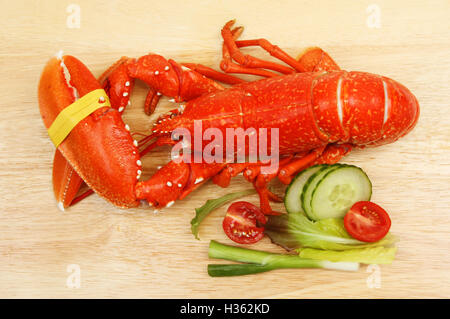 Ensemble de homard cuit avec salade sur une planche à découper en bois, vue du dessus Banque D'Images