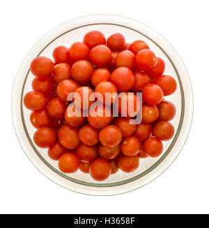 Shot verticale de tomates cerises dans un bol en verre clair sur un fond isolé Banque D'Images