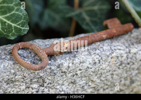 Perdu old rusty key allongé sur la pierre - faible profondeur de champ Banque D'Images