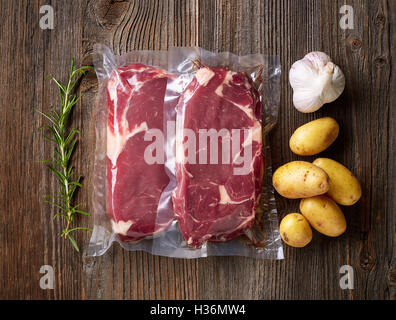 Steak de boeuf frais pour sous vide sur la table en bois Banque D'Images