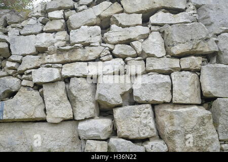 Mur de pierre de Portland de Portland, à la carrière de tout. Un petit visage sculpté est visible sur l'une des pierres. Banque D'Images