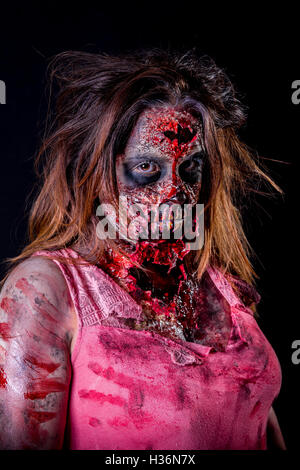 Portrait de femme zombie fixant avec du sang et de maquillage prothèse en latex. Banque D'Images