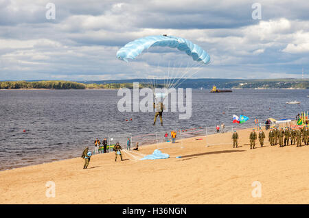 Les parachutistes militaires cavalier sur une aile parachute exécuter une descente contrôlée par le parachute sur une plage Banque D'Images