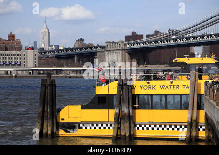 Un New York Water Taxi à Fulton Ferry Landing avec Manhattan Bridge & Empire State Building en arrière-plan.New York City.USA Banque D'Images