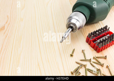 Perceuse électrique avec tournevis et vis sur un fond de bois Banque D'Images