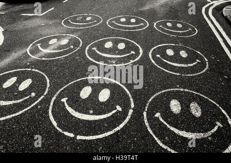Smiley faces peintes sur une route Banque D'Images