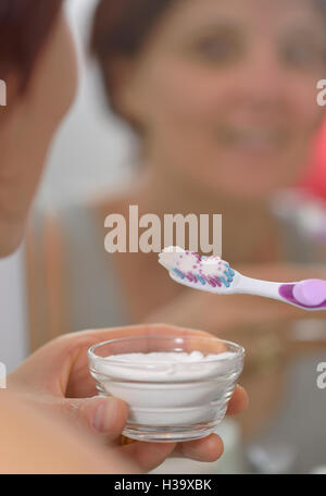 Femme l'éclaircissement des dents avec du bicarbonate de sodium Banque D'Images