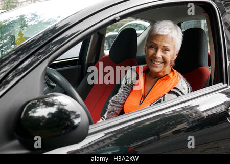 Femme mature dans sa voiture pilote Banque D'Images