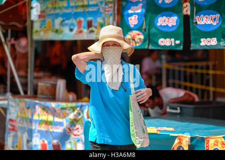 Femme masque. Femme portant un masque de protection contre la pollution. Thaïlande S. E. Asie Banque D'Images