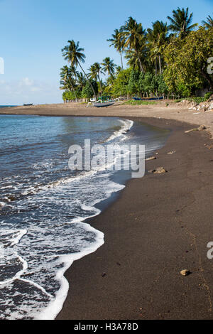 L'Indonésie, Lombok, Selengan, village de pêche, plage de sable volcanique noir Banque D'Images