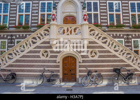 Les vélos en face de l'hôtel de ville historique d'Alkmaar, Pays-Bas Banque D'Images