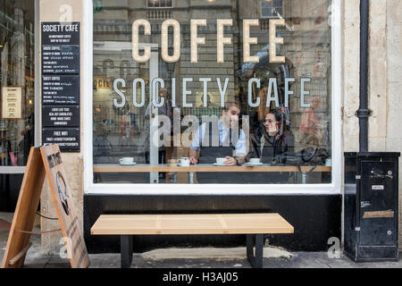 Les personnes qui boivent du café sont représentés assis à l'intérieur d'un café café à Bath, Angleterre, Royaume-Uni Banque D'Images