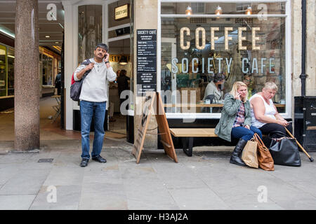 Les gens sont illustrés à l'intérieur et à l'assis à l'extérieur d'un café café à Bath, Angleterre, Royaume-Uni Banque D'Images