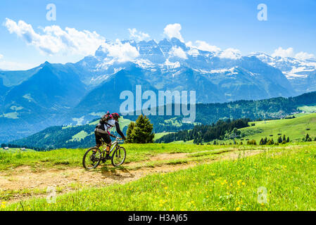 Coureur participant à Pass'Portes du Soleil MTB 2016, avec vue sur les Dents du Midi Banque D'Images