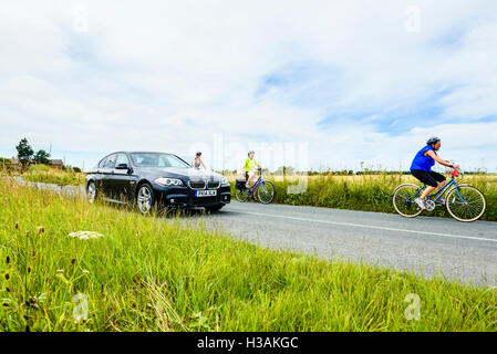 Une voiture passe groupe de femmes cyclistes sur route près de Hesketh Bank à West Lancashire England UK Banque D'Images